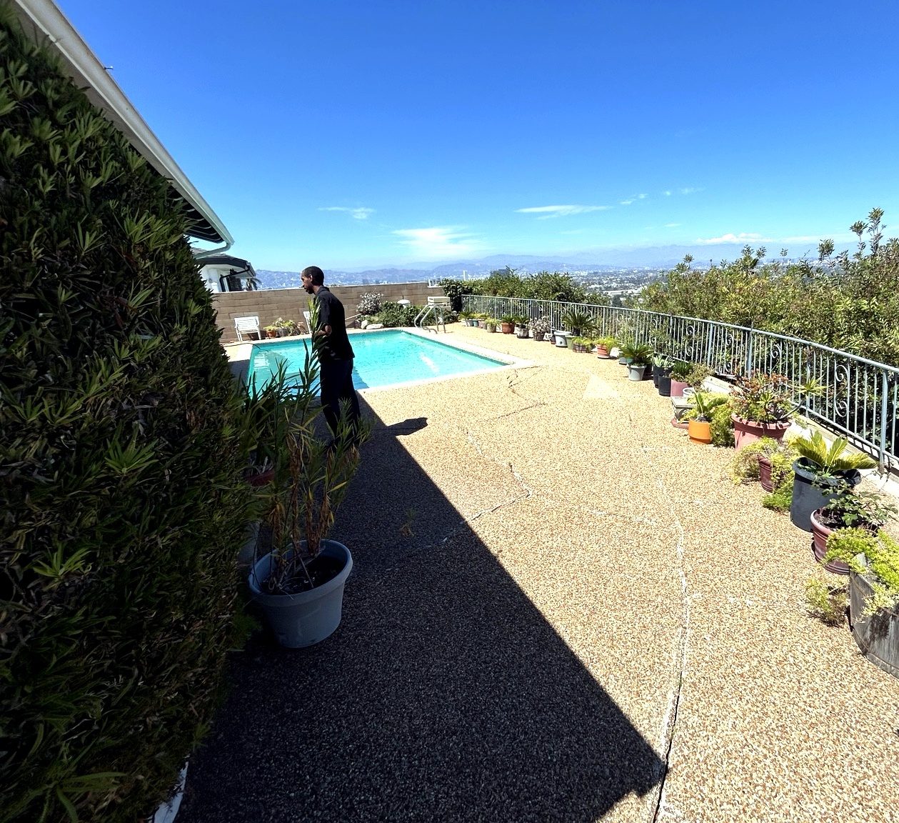 Owner standing by the pool overlooking the view