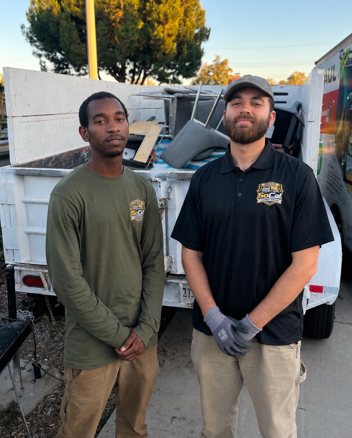 Owners of SoCal Cleanout Services standing by their truck